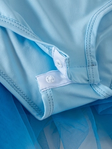 Detail view of crotch snap buttons on a light blue ballet leotard for toddler girls