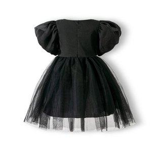 Detail of girls' black puff sleeve dress showing mesh layered skirt and sateen texture