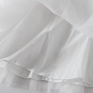 Detailed macro view of multi-layered white tulle skirt with high-quality stitching
