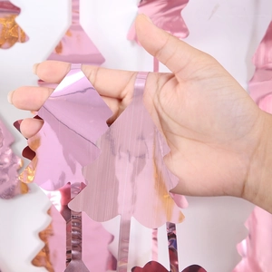 Close-up of metallic pink Christmas tree tinsel fringe curtain for festive party decor