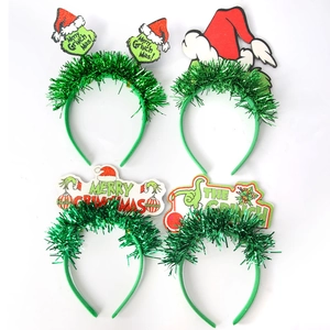 Detail view of four Grinch Christmas headbands with green tinsel and festive character motifs