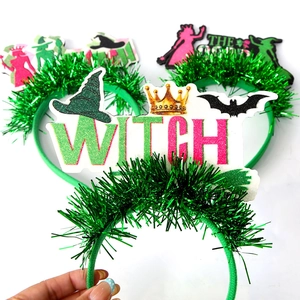 Close-up of green glitter Halloween headbands featuring WITCH letters and bat decorations