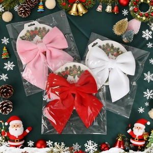 Christmas velvet bows in red pink and white with festive holiday cards and ornaments