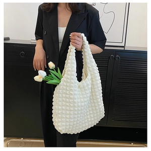 Detailed view of the puffy bubble texture on the large cream canvas tote bag with tulips