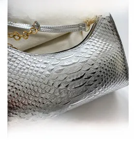 Detail shot of silver embossed faux leather shoulder bag with chunky gold chain