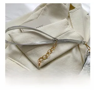 Close-up of the silver crocodile pattern leather surface and golden metal chain detail