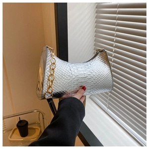 Silver metallic underarm bag with snake pattern texture and gold chain detail