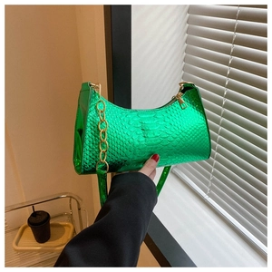 Detail of neon green snake pattern handbag with gold chain and crescent moon shape