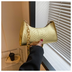 Detail of gold faux leather underarm bag with snake skin pattern and chunky chain strap