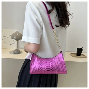 Detail of metallic purple faux leather shoulder bag with snake skin pattern and gold chain