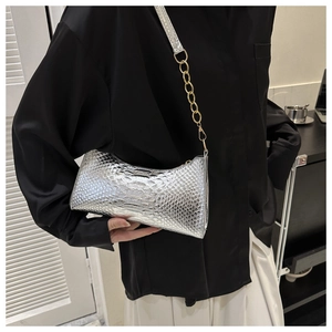 Detail of silver snake pattern crescent bag with gold chain on shoulder-carried model