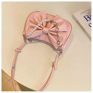 Top view of pink bow baguette bag with pearl chain and floral metal details