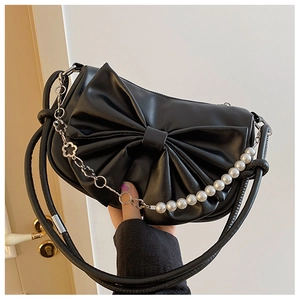 Close-up of black bow handbag with decorative pearl and metal flower short chain strap