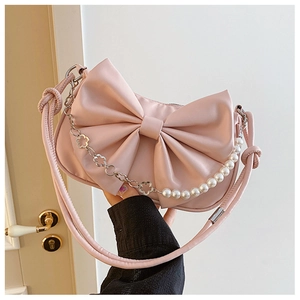 Detail of pink bow handbag featuring decorative hollow metal flowers and pearl chain strap