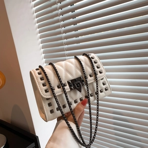 White quilted crossbody bag with stud detailing and dark metal chain strap for women
