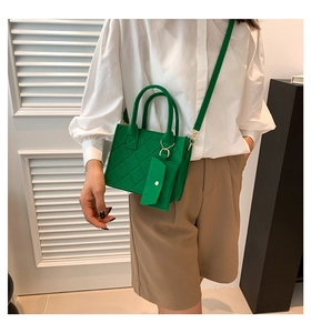 Detail of green felt crossbody bag with quilted diamond pattern worn by female model