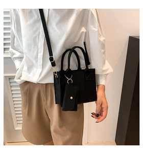 Close-up of black quilted felt crossbody bag with gold hardware and mini coin purse