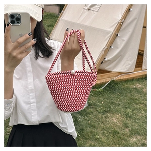 Detail der rot-weißen gewebten Strohtasche mit Hahnentrittmuster und Perlenverschluss