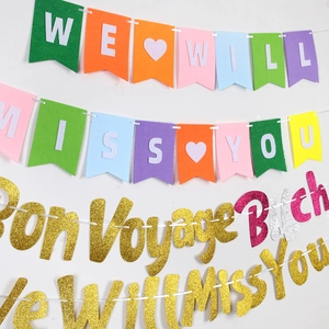Detail of glittery We Will Miss You and Bon Voyage banners with colorful felt hearts