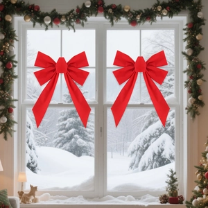 Pair of 23cm red velvet Christmas bows on snowy window for holiday home decoration