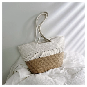 Detailed macro view of woven bicolor straw tote bag with wave pattern and rope handles