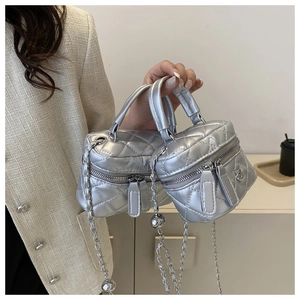 Detail of silver quilted mini box bag with metal chain strap and dual zippers