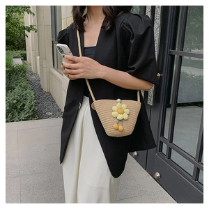 Straw mini bucket bag with yellow daisy embroidery and white bead clasp detail
