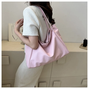 Détail d'un sac cabas rose léger assorti à une robe d'été blanche texturée