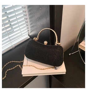 Detail of black sequin evening bag with gold handle and sparkling glitter texture