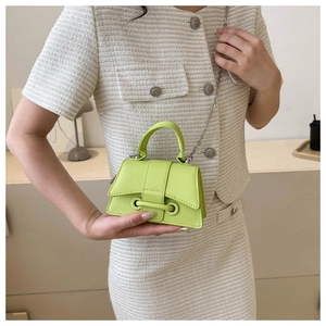 Neon green mini chain bag styled with a tweed suit in a minimalist modern room setting