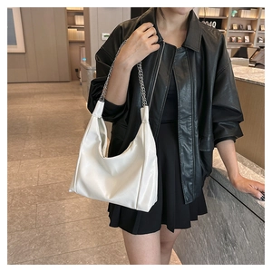 Gros plan d'un sac Hobo blanc avec bandoulière en chaîne argentée sur modèle