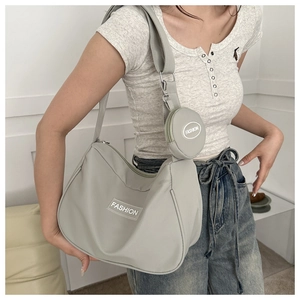 Dettaglio della borsa a tracolla in nylon grigio chiaro con etichetta e piccolo borsellino