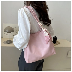 Detailed view of pink tote bag with woven handles and decorative floral silk scarf