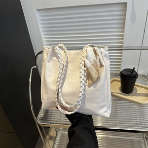 Elegant cream tote bag with woven handles and decorative silk scarf for daily use