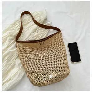 Détail du sac cabas tissé ajouré avec bandoulières en cuir marron et maille