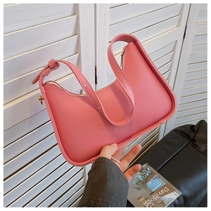 Detailed close-up of pink synthetic leather shoulder bag with gold zipper and hardware