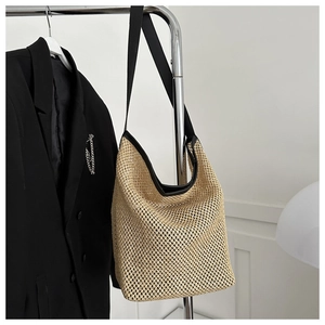 Détail du sac cabas en maille tissée beige avec sangle noire et design ajouré