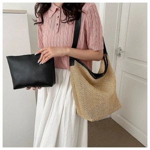 Détail d'un sac cabas en paille tissée avec bandoulière en cuir noir et pochette