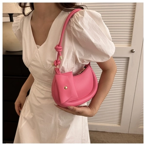 Pink crescent underarm bag with knot strap and mini envelope pouch on model