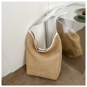 Détail du sac cabas beige tressé avec bandoulières blanches et texture maille ajourée