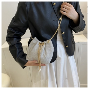 Détail du sac seau argenté en strass avec cordon de serrage et bandoulière dorée
