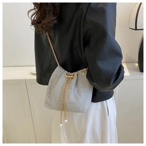 Détail du sac seau à paillettes argentées avec chaîne dorée et glands en perles