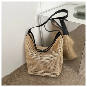 Gros plan du sac cabas tissé avec bordure en cuir noir et fermoir magnétique