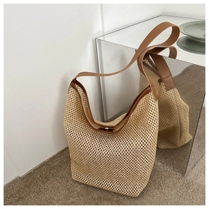 Détail du sac cabas en paille avec tissage ajouré et bandoulière en similicuir marron