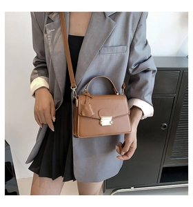 Bruine retro crossbodytas met goudkleurig slot getoond op model voor de maat