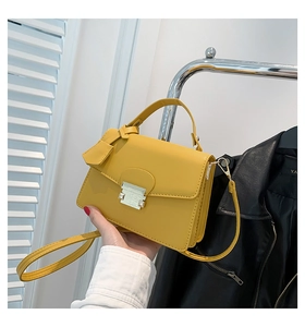 Detail van gele crossbodytas met stijlvol metalen slot en een verstelbare fijne schouderriem