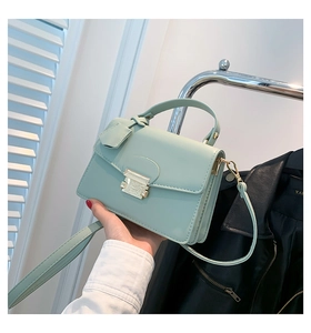 Detail van mintgroene PU-lederen mini-kleptas met goudkleurige vierkante push-sluiting