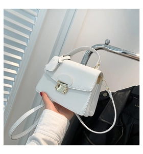 Gedetailleerd zijaanzicht van de witte lederen crossbodytas met plooien en gouden gesp