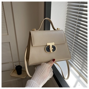 Detail view of the elegant beige PU leather handbag with a gold T-shaped clasp