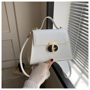 Close-up of white PU leather square bag with elegant gold T-shaped clasp and hand strap